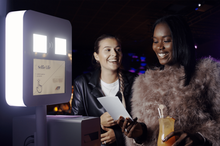 Deux invitées découvrent leur photo imprimée par le photobooth