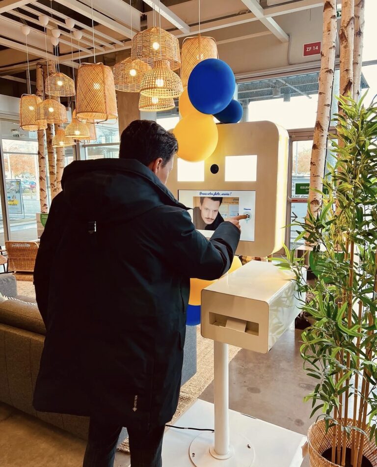 Client utilisant l’écran tactile du photobooth en libre-service dans un magasin