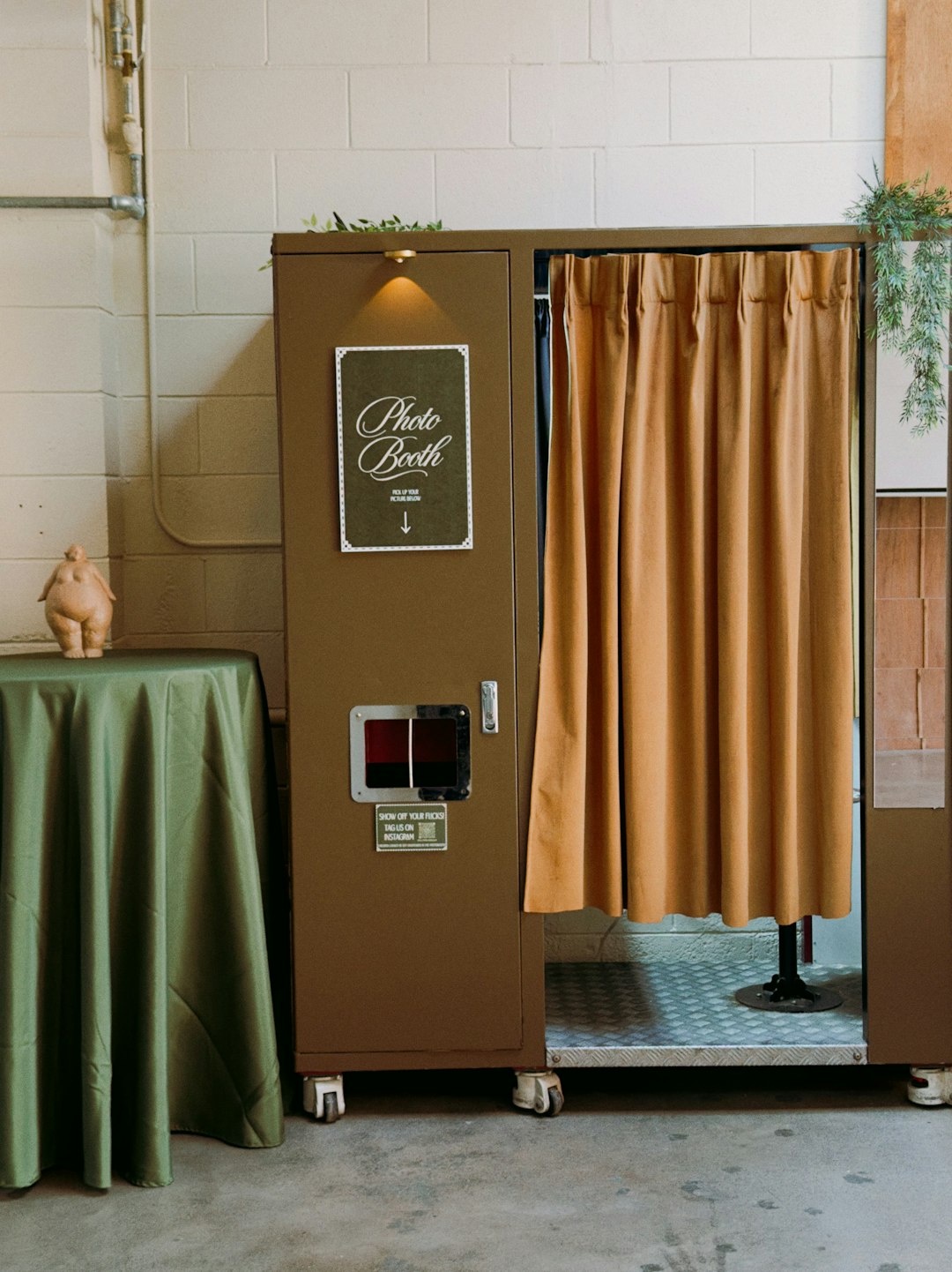 Cabine photo automatique vintage avec rideau beige, l'ancêtre du photobooth d'événement