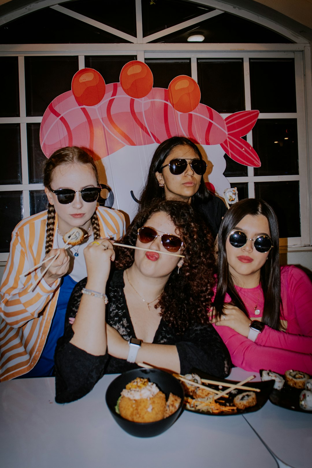 groupe-d-amis-posant-ensemble-devant-l-objectif-lors-d-une-f Groupe d'amis posant ensemble devant l'objectif lors d'une fête, ambiance photobooth